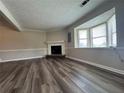Bright living room with wood floors, fireplace, and a large window letting in natural light at 8170 Canyon Forge Dr, Riverdale, GA 30274