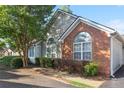 A well-maintained home featuring brick and siding, and arched windows, surrounded by lush greenery at 3707 Vineyards Lake Nw Cir # 22, Kennesaw, GA 30144