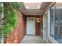 Inviting front entrance with brick facade, white door with sidelights and covered porch with brick flooring at 3707 Vineyards Lake Nw Cir # 22, Kennesaw, GA 30144
