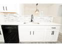 Modern kitchen featuring white cabinets, a stainless steel sink, quartz countertops, and black appliances at 2504 Hannah Haven Dr, Conyers, GA 30012
