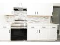 Contemporary kitchen featuring white cabinets, stone backsplash, stainless steel appliances, and quartz countertops at 2504 Hannah Haven Dr, Conyers, GA 30012