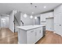 View of kitchen island, stainless steel dishwasher, and staircase in an open floor plan at 6096 Marigold Way, Atlanta, GA 30349
