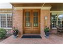 Inviting brick front porch featuring a double door entrance, potted plants, and rocking chair at 3560 Greenside Ct, Dacula, GA 30019