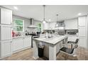 Bright kitchen featuring white cabinets, stainless steel appliances, and large center island at 55 Forest Rd, Stockbridge, GA 30281