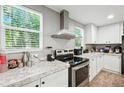 Modern kitchen with stainless steel range hood, appliances and ample counter space at 55 Forest Rd, Stockbridge, GA 30281
