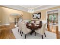 Formal dining room with hardwood floors, chandelier, and wainscoting adjacent to staircase at 917 Saints Ct, Marietta, GA 30068