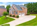 A well-maintained home with a spacious driveway leading to a two-car garage and lush green lawn at 917 Saints Ct, Marietta, GA 30068