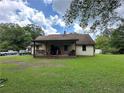Charming home features a cozy front porch and a spacious green lawn surrounded by mature trees at 3398 Highway 81, Oxford, GA 30054