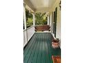 Inviting porch with a swing and a green painted wood floor at 5904 Clairmont Way, Powder Springs, GA 30127