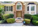 Elegant front entrance with stone accents, double doors, and professionally landscaped surroundings at 1811 Ascot Nw Cv, Acworth, GA 30102