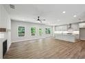Open living room with hardwood floors, a fireplace, abundant natural light, and seamless transition to a modern kitchen at 3159 Stonegate Sw Dr, Atlanta, GA 30331