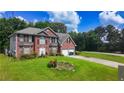 A lush front lawn leads up to a well-maintained brick home with an attached two-car garage at 1455 Duren Farms Dr, Lithonia, GA 30058