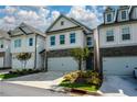 Charming townhome features stone accents, a two-car garage, and professionally landscaped front yard at 428 Whitetail Cir, Canton, GA 30115