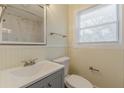 Updated bathroom with modern vanity, toilet, tiled shower, and window for natural light at 1885 N Druid Hills Ne Rd, Atlanta, GA 30319