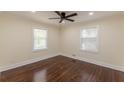 Comfortable bedroom with two windows allowing natural light and featuring a ceiling fan and hardwood flooring at 1885 N Druid Hills Ne Rd, Atlanta, GA 30319