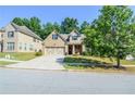 Well-maintained brick home featuring a manicured lawn and driveway, and lovely landscaping at 2436 Loughridge Dr, Buford, GA 30519