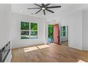 Sun-filled living room with hardwood floors, a stylish ceiling fan, and a modern fireplace at 1835 Taylor Ave, East Point, GA 30344