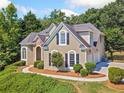 Charming home featuring manicured landscaping, stone accents, arched windows, and black shutters at 3845 Overlake Dr, Cumming, GA 30041