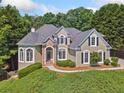 Charming home featuring manicured landscaping, stone accents, arched windows, and black shutters at 3845 Overlake Dr, Cumming, GA 30041