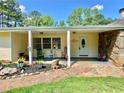 Inviting front porch with stone accents and potted plants, leading to the front door at 7680 Banks Mill Road Rd, Douglasville, GA 30135