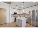 Modern kitchen has stainless appliances, white cabinets, quartz counters, and kitchen island at 860 Peachtree St # 1103, Atlanta, GA 30308