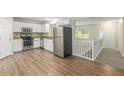 Open kitchen featuring stainless steel appliances, white cabinets, and hardwood floors at 7420 Bristol Cir, Douglasville, GA 30134