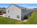 Rear view of townhouse featuring a grassy backyard and privacy fence at 161 Swindon Dr, Mcdonough, GA 30253