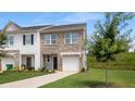Charming brick and siding townhouse with a well-manicured lawn and attached garage at 161 Swindon Dr, Mcdonough, GA 30253