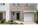 Close-up of a charming townhome featuring a front door, one car garage, and a well-manicured front yard at 161 Swindon Dr, Mcdonough, GA 30253