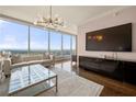 Bright living room features floor-to-ceiling windows with stunning views, modern chandelier, and sleek entertainment center at 3630 Peachtree Ne Rd # 2706, Atlanta, GA 30326