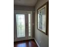 Elegant entryway featuring a decorative glass door, wood floors, and a framed art piece on the wall at 979 Simonton Glen Dr, Lawrenceville, GA 30045