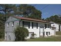 A charming home featuring classic white siding, complemented by black shutters and a well-maintained lawn at 1417 Pineglen Dr, Riverdale, GA 30296