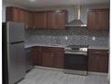 Modern kitchen with stainless steel appliances, granite countertops, stylish backsplash and dark wood cabinets at 1417 Pineglen Dr, Riverdale, GA 30296