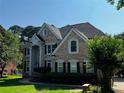 Beautiful brick home with a manicured lawn, showcasing classic architectural details and mature trees at 2550 Lynshire Ln, Snellville, GA 30078