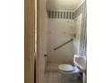 Small bathroom with a white toilet, sink, shower, grab bar, and striped wallpaper at 4595 Sahara Sw Dr, Atlanta, GA 30331