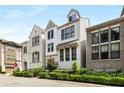 Charming, modern, three-story white brick home with black-trimmed windows, black metal fence, and verdant landscaping at 506 Broadview Ne Pl, Atlanta, GA 30324