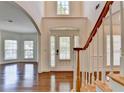 Elegant foyer featuring hardwood floors, a staircase with white railings, and a front door with sidelights at 5485 Sandstone Ct, Cumming, GA 30040