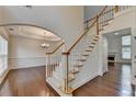 Bright foyer with hardwood floors, staircase, and an archway leading to the dining room at 5485 Sandstone Ct, Cumming, GA 30040