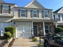 Two-story townhome featuring an attached garage and a classic facade at 127 Spring Way Sq, Canton, GA 30114