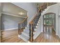 View of staircase with hardwood floors, and wrought iron balusters at 1723 Woodbow Path, Dacula, GA 30019