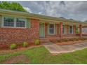 Close up of the red brick facade and front entrance with a painted green door and shutters at 4601 Lindsey Dr, Powder Springs, GA 30127