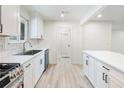 Modern kitchen with stainless steel sink, updated appliances, white cabinetry, and tile backsplash at 4059 Big Valley Trl, Stone Mountain, GA 30083
