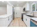 Updated kitchen featuring stainless steel appliances, white cabinets, modern fixtures, and new flooring at 4059 Big Valley Trl, Stone Mountain, GA 30083