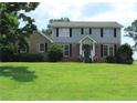Lovely two-story home with a brick and light blue facade, complemented by a lush green lawn at 4814 Delgado Dr Sw, Lilburn, GA 30047