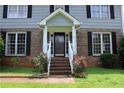 Inviting front entrance featuring brick steps, white railings, and lovely flower bushes at 4814 Delgado Dr Sw, Lilburn, GA 30047