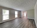 The bright living room features large windows, new floors, and flows into the dining room and staircase at 650 Lake Forest Ct, Roswell, GA 30076