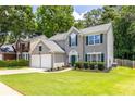 View of an attractive two-story house with a well-kept lawn, an attached two-car garage, and mature trees at 7000 Foxberry Ln, Roswell, GA 30075