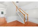 Bright foyer showcasing hardwood floors, elegant staircase with wood railing, and neutral walls at 7000 Foxberry Ln, Roswell, GA 30075