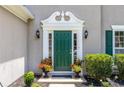 Elegant front door with decorative trim, flanked by sconces and planters with colorful flowers adding curb appeal at 7000 Foxberry Ln, Roswell, GA 30075