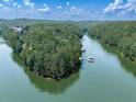 Scenic view of waterfront property with boat docks, perfect for lake living, amidst lush greenery and tranquil waters at 7560 Island Mill Rd, Acworth, GA 30102